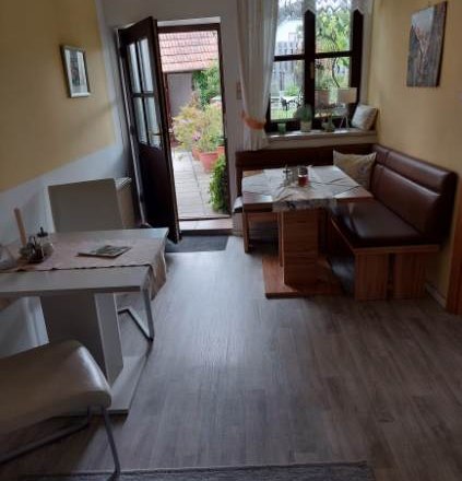 Gästezimmer Weixelbaum, © Familie Weixelbaum Gemütliches Gästezimmer mit Esstisch, Stühlen und Bank, Blick auf Terrasse.