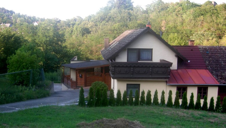 Privatzimmer Gruber, © Siegfried Gruber Ein Haus mit Balkon und Garten, umgeben von Bäumen und Hügeln.