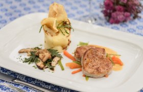 Genuss im Restaurant Loibnerhof, © Rita Newman Gourmetgericht mit Fleisch, Kartoffelpüree und Gemüse auf weißem Teller.