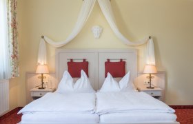 Zimmer Hotel Wachau, © Hotel Wachau Zimmeransicht mit Himmelbett und roten Polstern