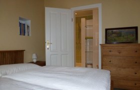 Doppelzimmer, © Wolfgang Pollak Ein gemütliches Doppelzimmer mit Bett, Kommode, Bücherregal und offenem Bad.