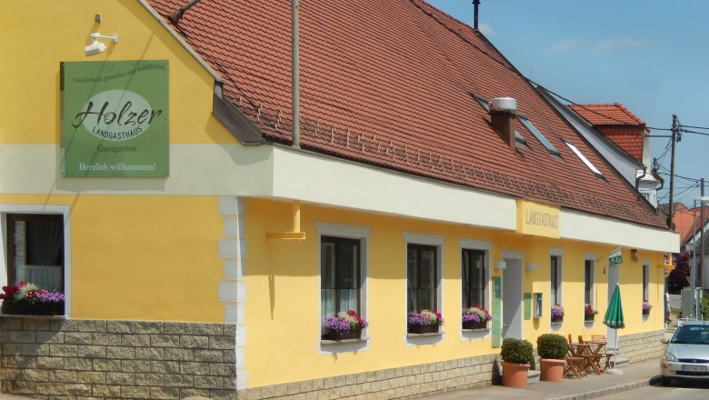 Landgasthaus Holzer, © Klaus Rubik Gelbes Landgasthaus mit roten Dachziegeln und Blumenkästen vor den Fenstern.