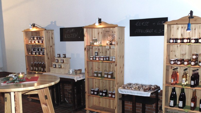 Hofladen, © Heiderer Innenansicht eines Hofladens mit Regalen voller Marmeladen, Säften und Keksen.