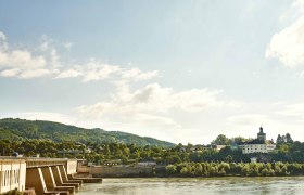 Besucherkraftwerk Ybbs Persenbeug, © Klaus Engelmayer Kraftwerk Ybbs-Persenbeug an einem sonnigen Tag mit Fluss und bewaldeten Hügeln im Hintergrund.