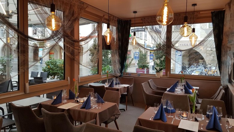 Reef & Beef innen, © Piroska Weiss Innenansicht eines stilvoll eingerichteten Restaurants mit gedeckten Tischen und großen Fenstern.