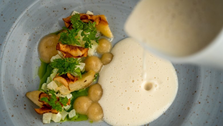 Feine Küche im Sporthotel, © Sporthotel Semmering Gourmetgericht mit Schaum und Gemüse auf einem Teller.