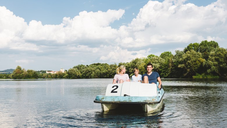 Tretbootfahren am Donausee in Weitenegg, © NÖW_Stefan Fürtbauer Drei Personen auf einem Tretboot auf einem See mit Bäumen im Hintergrund.