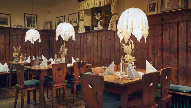 Urige Stube, © Niederösterreich Werbung/Andreas Hofer Gemütliche Stube mit Holzmöbeln, Tischdekoration und hängenden Lampen.