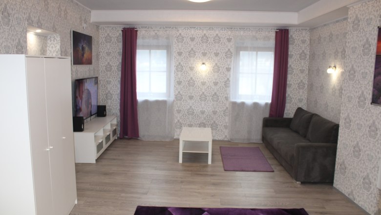 Haus Donau Wohnraum, © Haus Donau, Hr. Benesics Wohnzimmer mit weißen Möbeln und grauer Couch