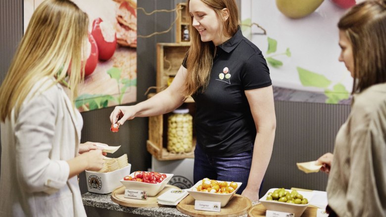Verkostung, © Waldviertel Tourismus, Gerhard Wasserbauer Eine Frau bietet zwei anderen Frauen verschiedene gefüllte Paprikas und Oliven zur Verkostung an.
