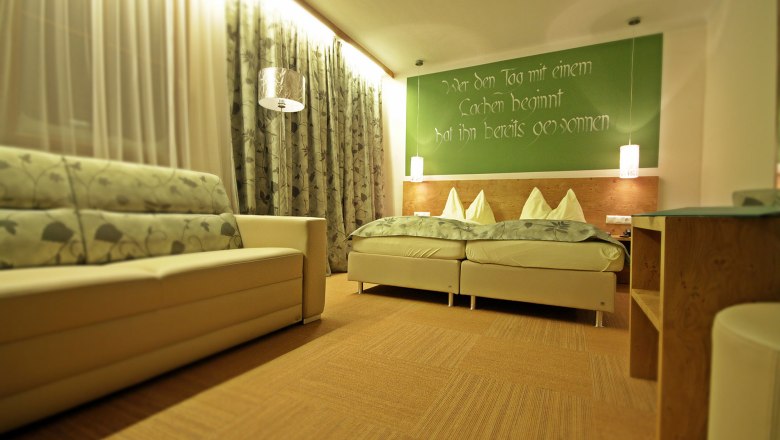 Gemütliche Gästezimmer, © Forellenhof, Franz Zwickl Gemütliches Gästezimmer mit Doppelbett, Sofa und dekorativen Vorhängen.