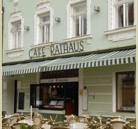 Café-Pub Rathaus, © Café-Pub Rathaus Außenansicht eines Cafés mit Terrasse und gestreifter Markise.