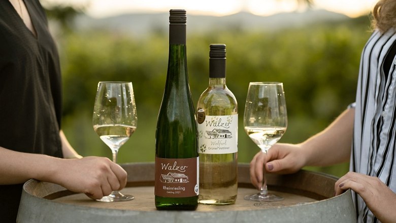 walzer-johann-77, © Weinbau Johann Walzer Zwei Weinflaschen und Gläser auf einem Weinfass im Freien.