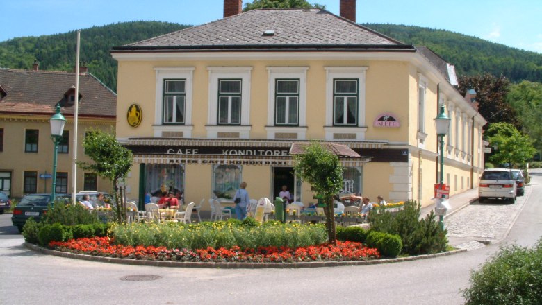 Café Konditorei Alber in Payerbach, © Café Konditorei Alber Café Konditorei Alber in Payerbach mit Außenbereich und Blumen davor.