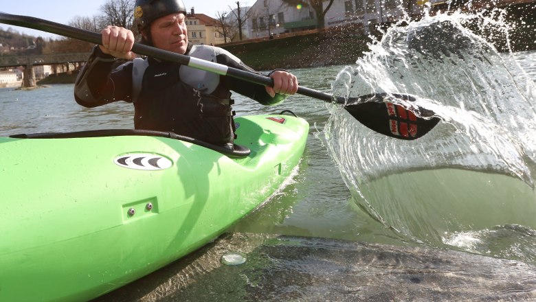Auf Bootstour auf der Erlauf, © schwarz-koenig.at Person in grünem Kajak paddelt auf einem Fluss.