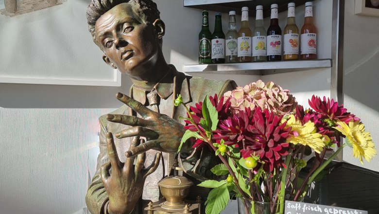 TDR-Egon to go-Statue innen, © Yana Tereshchenko Egon Schiele Statue im Fenster mit Blumenstrauss