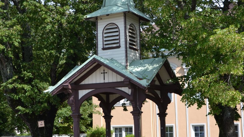 Felixdorf, © Gemeinde Felixdorf Ein kleiner Pavillon mit spitzem Dach und Kreuz, umgeben von Bäumen.