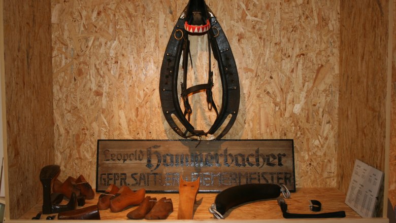 Ansicht Museum/Gewerbe, © Gemeinde Schrattenberg Ausstellungsstück in einem Museum mit Sattlerwerkzeugen und einem Pferdegeschirr.