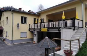 gasthaus-spenger, © Gemeinde Lichtenegg Gelbes Gasthaus mit Terrasse und Treppe.