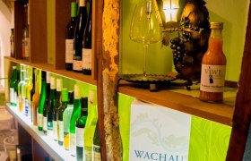 Ansicht Weinbar, © Viwe Vinothek und Weinbar Regal mit Weinflaschen und Dekoration in einer Weinbar.