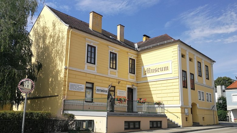 Zeitbrücke Museum, © Roman Zöchlinger Gelbes Gebäude mit der Aufschrift 'Museum' und 'Zeitbrücke'.
