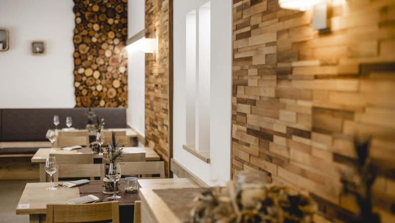 Liebevolle Dekoration der Wirtin, © Niederösterreich Werbung/David Schreiber Gemütliches Restaurant mit Holzwänden und dekorierten Tischen.
