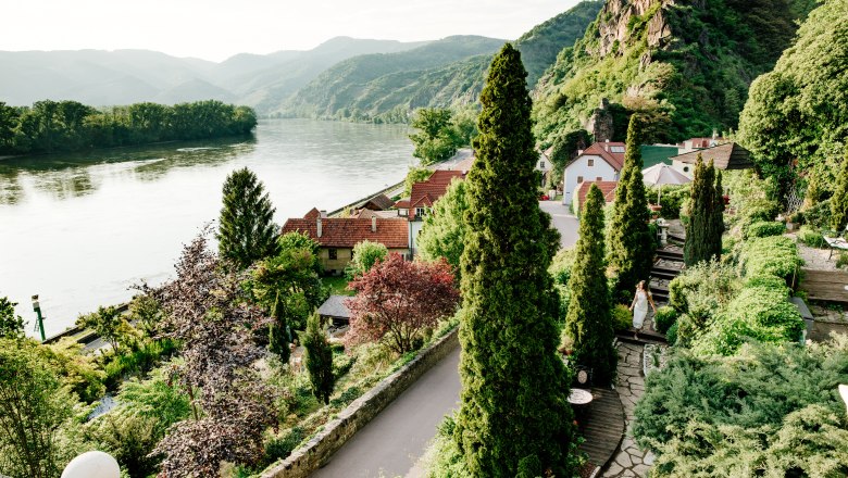 villa_schonthal-29_2, © Julius Hirtzberger Blick auf eine malerische Landschaft mit Fluss, Bergen und üppigen Gärten.