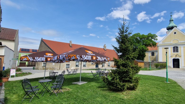 WunderBar Wolfsthal Garten, © WunderBar WunderBar Wolfsthal Garten mit Tischen, Sesseln und Sonnenschirmen