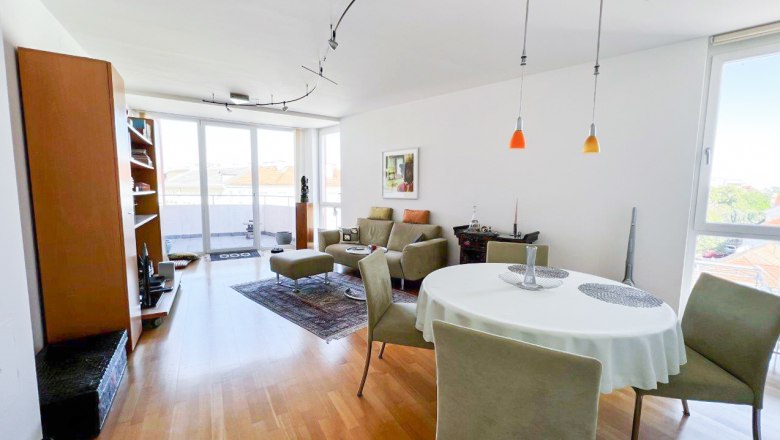 Apartment am Stadtpark, © Apartment am Stadtpark Modernes Wohnzimmer mit Holzboden, Esstisch und großen Fenstern.