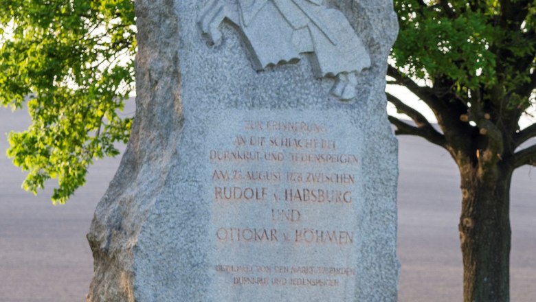 Gedenkstein Jedenspeigen, © Marktgemeinde Jedenspeigen Gedenkstein mit Ritterrelief und Inschrift, umgeben von Bäumen und Wiese.