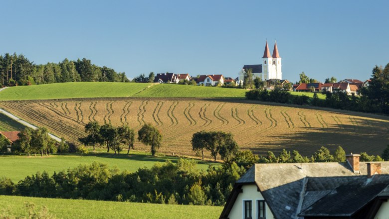 Gemeinde Lichtenegg, © Wiener Alpen, Franz Zwickl Landschaft mit den Spitzen der Wallfahrtskirche Maria Schnee und Feldern in Lichtenegg.
