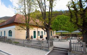 Aggsteinerhof Aussenansicht, © Daniels Außenansicht eines gelben Gebäudes mit rotem Dach und Biergarten.