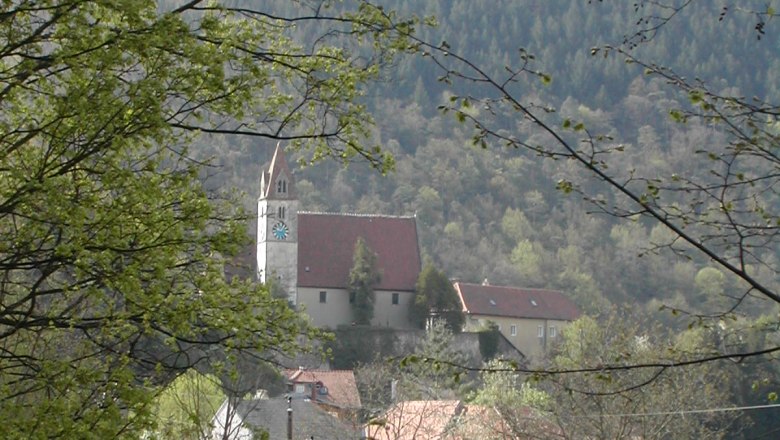 Pfarrkirche Senftenberg, © Gemeinde Senftenberg Pfarrkirche Senftenberg umgeben von Bäumen und Hügeln.