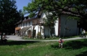 Hirmhof, © Hirmhof Ein traditionelles Bauernhaus mit Holzbalkon und grünem Garten im Vordergrund.