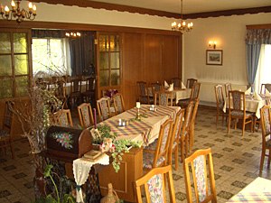 Extrazimmer, © Gasthof Kögl Ein gemütlicher Speiseraum mit Holzmöbeln und dekorierten Tischen.