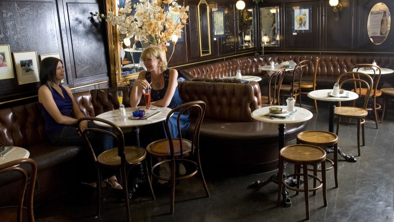 Café Berger Krems, © Café Berger Krems Innenansicht eines traditionellen Cafés mit zwei Frauen, die an einem Tisch sitzen.