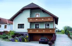 Gästehaus Kocaget, © Gästehaus Kocaget Ein zweistöckiges Haus mit Holzbalkon und Garten.