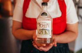 International prämierte Edelbrände, © Niederösterreich Werbung/Daniela Führer Person hält eine Flasche Krenn Gin mit Auszeichnungsetikett.