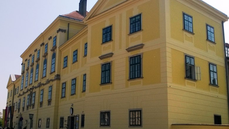 Schloss, © Stadtgemeinde Mannersdorf Gelbes historisches Gebäude mit vielen Fenstern und einem Giebeldach.