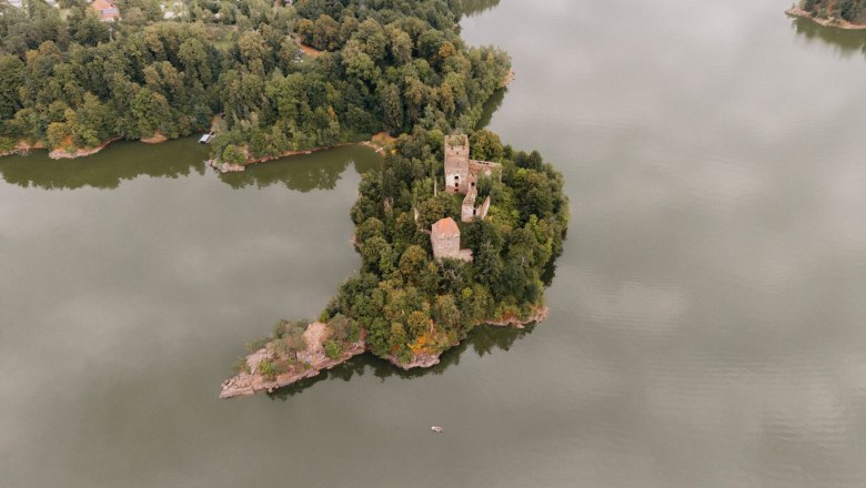 Ruine Lichtenfels, © Patrick Wasshuber Luftaufnahme einer Burgruine auf einer bewaldeten Insel in einem See.