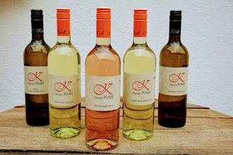 Weingut Krell, © Weingut Krell Fünf Weinflaschen vom Weingut Krell auf einem Holztisch.