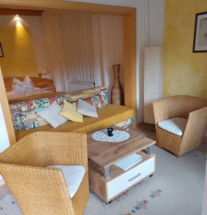 Gästezimmer Weixelbaum, © Familie Weixelbaum Gemütliches Gästezimmer mit Rattanmöbeln und buntem Sofa.