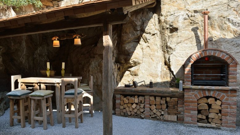 Heritage Dürnstein, © Gregor Semrad Rustikaler Außenbereich mit Holztisch, Stühlen und gemauertem Ofen.