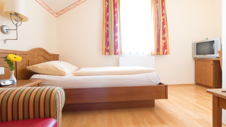 Einzelzimmer, © Foto Weidinger Einzelzimmer mit Bett, Fernseher und Sessel.