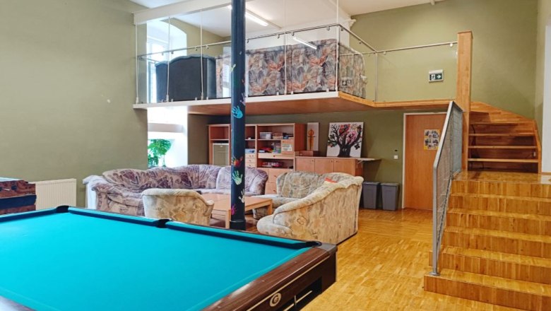 Jugendraum, © Melanie Köberl / Agnes Stefanie Wagner Ein Jugendraum mit Billardtisch, Sofas und einer Empore mit Treppe.