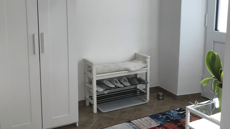 Vorraum der Ferienwohnung, © Familie Krenn Vorraum einer Ferienwohnung mit Schuhregal, Bank und Pflanze.