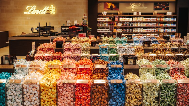 Riesen Auswahl, © Philipp Lipiarski Ein Geschäft mit einer großen Auswahl an bunten Lindt-Pralinen in durchsichtigen Behältern.