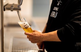 Schwarzbräu, © Wiener Alpen, Christian Kremsl Eine Person zapft Bier in ein Glas mit der Aufschrift "Schwarzbräu".