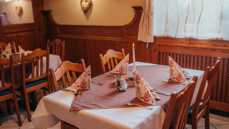 Gemütlich mit Platz für Gesellschaften, © Niederösterreich Werbung/Daniela Führer Gemütlich gedeckter Tisch in einem rustikalen Restaurant mit Holzverkleidung.