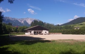 Wohnmobilstellplatz Schneebergblick, © Rosemarie Alber Ein Gebäude auf einem Campingplatz mit Blick auf einen Berg im Hintergrund.